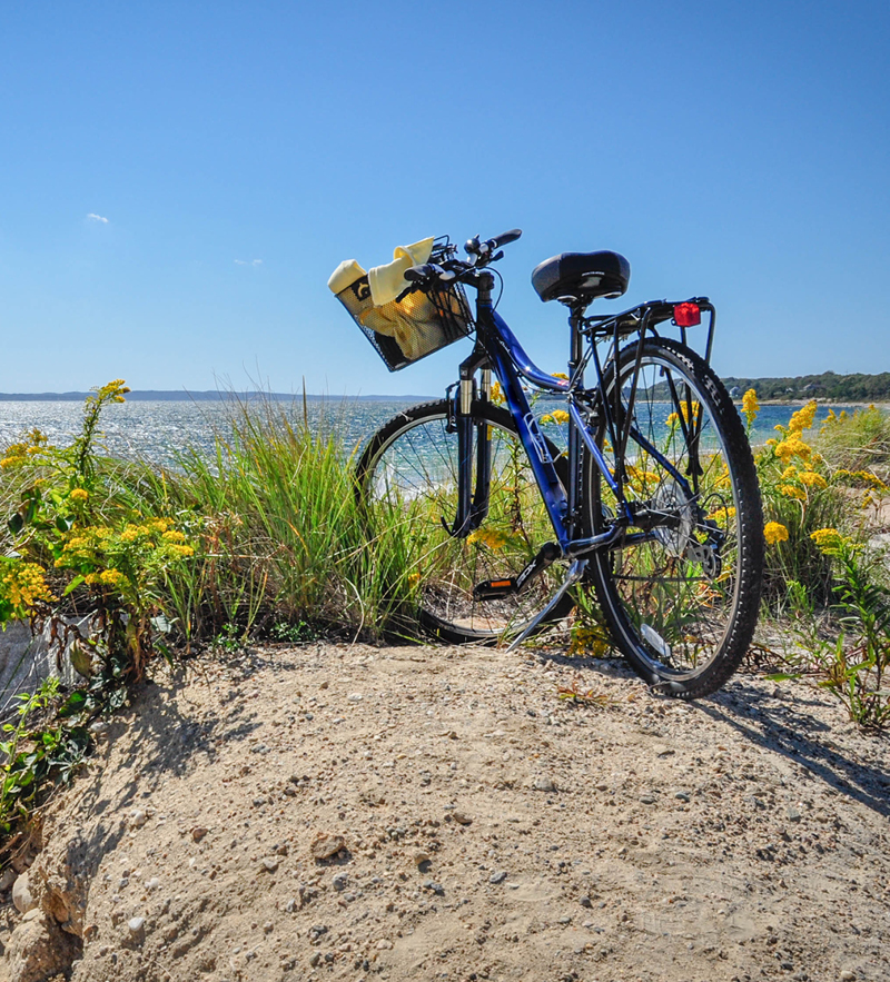 A bicycle resting in front of the beach at Camp Fairbridge