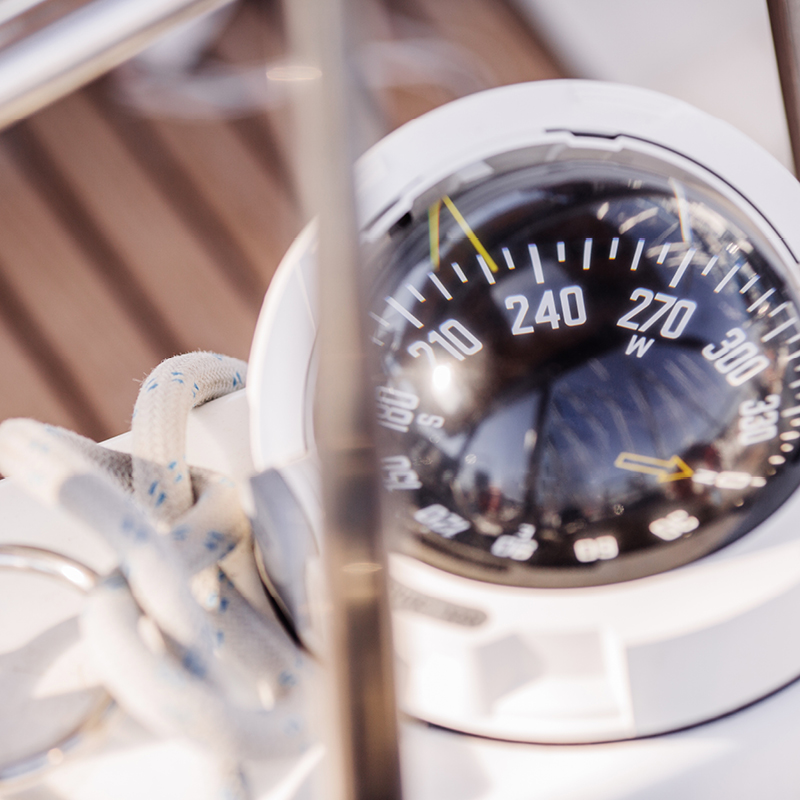 Close-up of a compass on a boat, essential for sailing skills taught at Camp Fairbridge