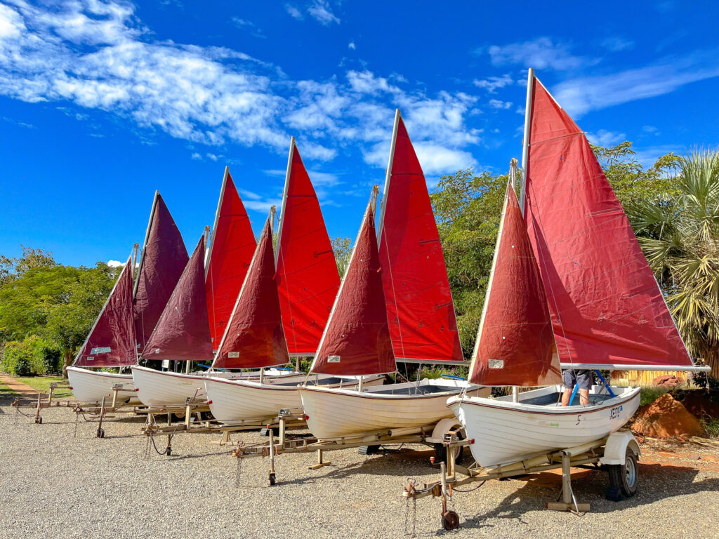 Vibrant sailboats resting on the sandy beach at Camp Fairbridge