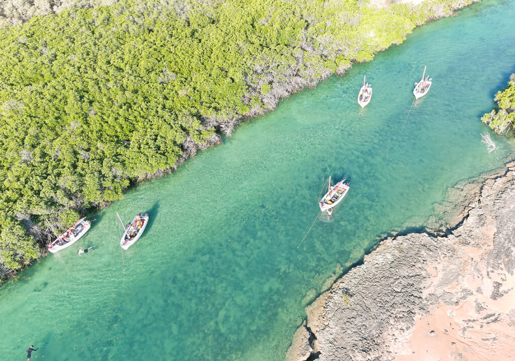 Five boats sail on the stunning, beautiful lake at Camp Fairbridge
