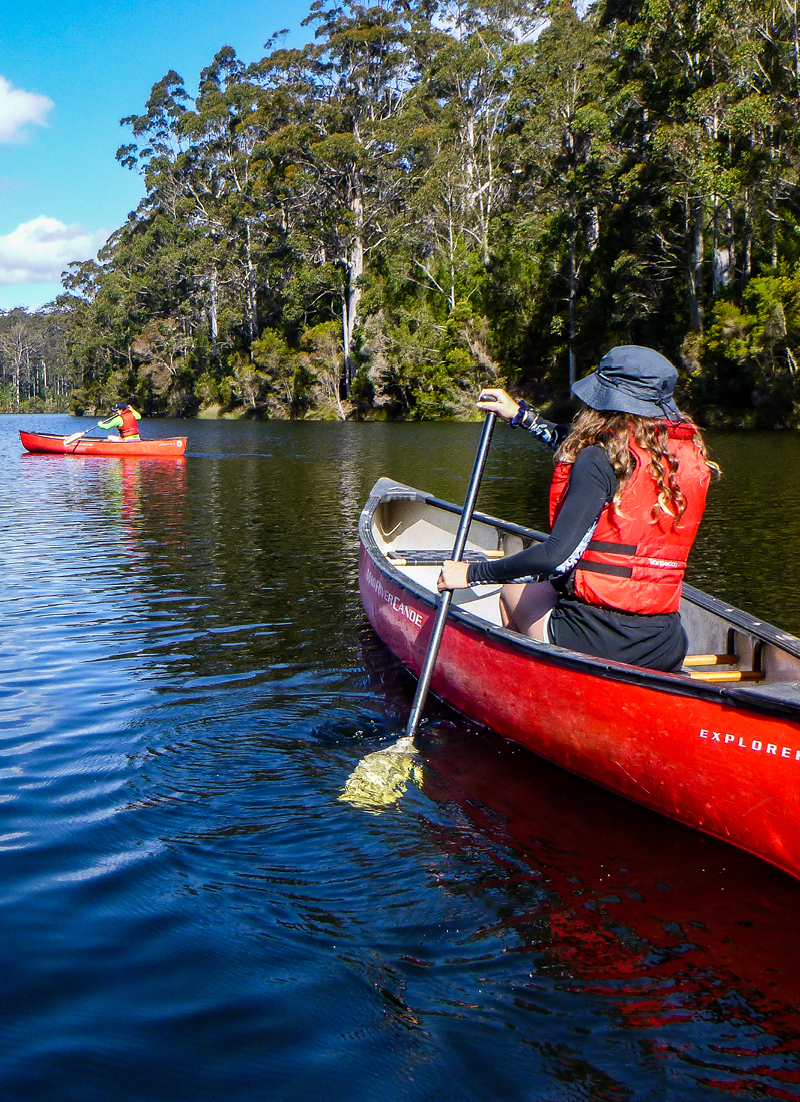 Two people wearing life vests enjoy kayaking at Pemberton Camp on Fairbridge Lake