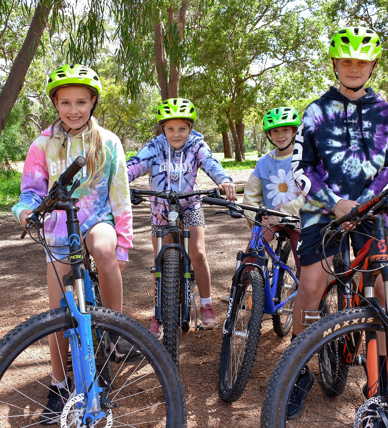 Group of children wearing helmets for safety while mountain biking at Geraldton camping site, Camp Fairbridge